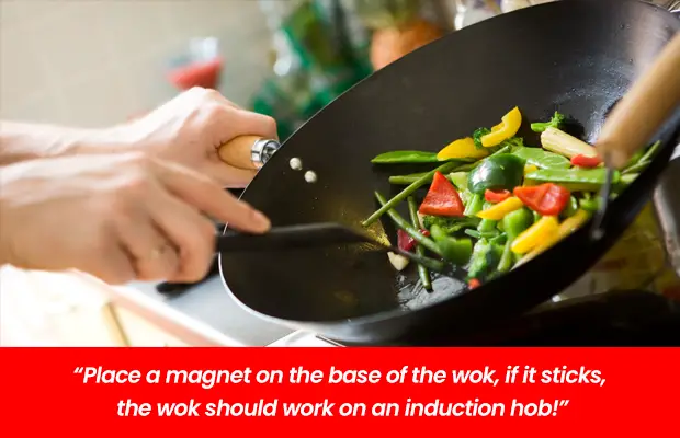 man cooking with wok on induction hob